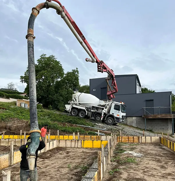 Ouvrier qui fait couler du béton pour une maison