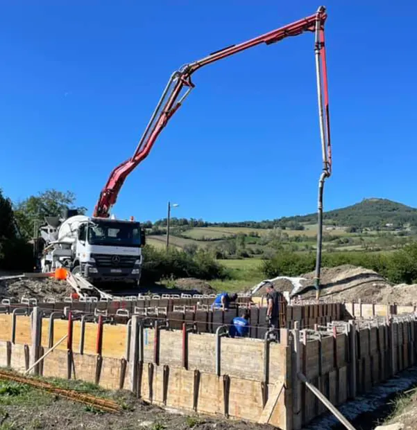 Camion toupie qui coule du béton pour des fondations de maison